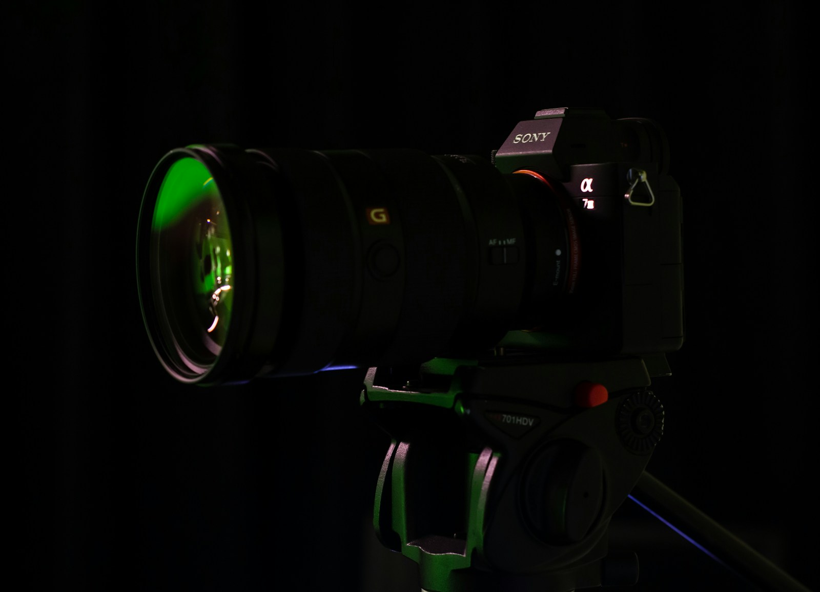 a camera with a green lens on a tripod